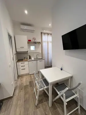 a kitchen with a white table and two chairs and a tv at Rome Groove Rooms in Rome