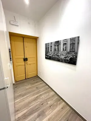 a hallway with a yellow door and a painting on a wall at Rome Groove Rooms in Rome