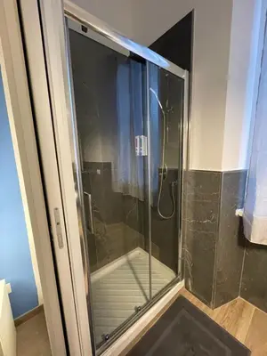 a shower with a glass door in a bathroom at Rome Groove Rooms in Rome