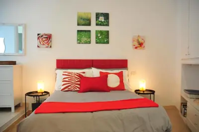a bedroom with a large bed with two lamps at CARDINAL STUDIO - 2 steps from Vatican & Ottaviano metro in Rome