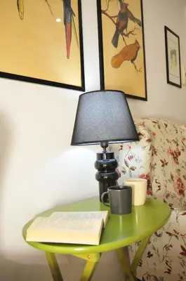 a table with a lamp and a book on it at CARDINAL STUDIO - 2 steps from Vatican & Ottaviano metro in Rome