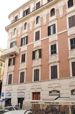a large brick building with windows on a street at CARDINAL STUDIO - 2 steps from Vatican & Ottaviano metro in Rome