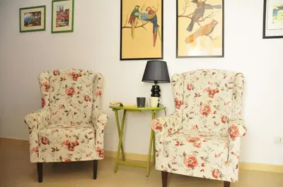 a room with a chair and a table with a lamp at CARDINAL STUDIO - 2 steps from Vatican & Ottaviano metro in Rome