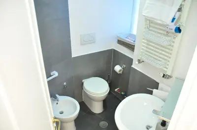 a small bathroom with a toilet and a sink at CARDINAL STUDIO - 2 steps from Vatican & Ottaviano metro in Rome