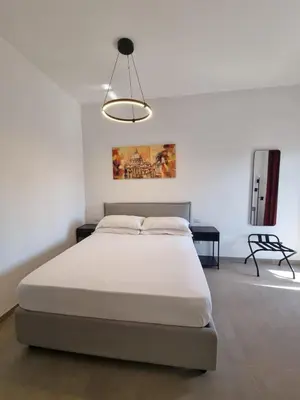 a bedroom with a large bed and a light fixture at Sunshine Suite in Rome
