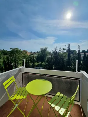 a green table and two chairs on a balcony at Sunshine Suite in Rome