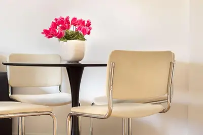 two chairs and a table with a vase of flowers on it at Cozy & Chic Apartment - Piazza Bologna in Rome