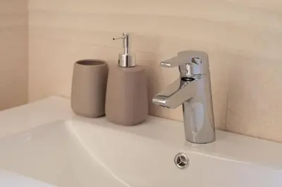 a bathroom sink with a faucet and two cups at Cozy & Chic Apartment - Piazza Bologna in Rome