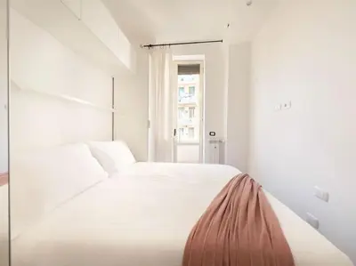 a white bed in a white room with a window at Cozy & Chic Apartment - Piazza Bologna in Rome