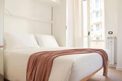 a white bed in a room with a window at Cozy & Chic Apartment - Piazza Bologna in Rome