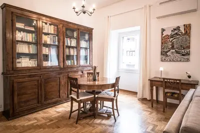 a dining room with a table and a large wooden cabinet at Esa apartment Flaminio in Rome