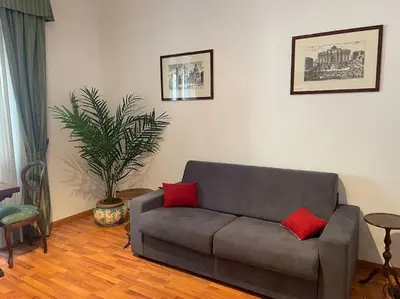 a living room with a gray couch with two red pillows at Interno 3 - Vatican Apartment in Rome