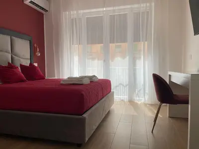 a bedroom with a red bed with a chair and a window at Wow Rome Home in Rome