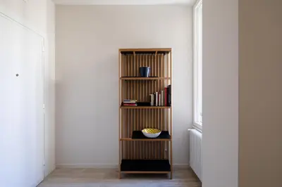 a book shelf in a hallway next to a window at Suite Lucrezio in Rome in Rome