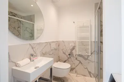 a bathroom with a sink and a toilet and a mirror at Suite Lucrezio in Rome in Rome