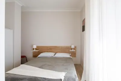 a bedroom with a bed with a wooden headboard at Suite Lucrezio in Rome in Rome