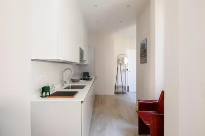 a white kitchen with a sink and a counter at Suite Lucrezio in Rome in Rome