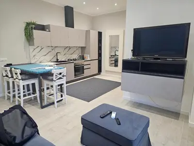a living room with a television and a table with a stool at EMHouse in Rome
