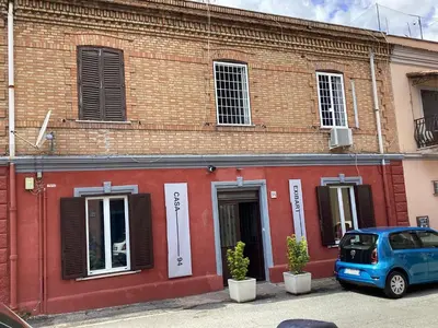 a blue car parked in front of a brick building at casa galleria d'arte in Rome