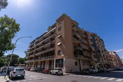 a tall building with cars parked in a parking lot at 3Storie Vatican St Peter in Rome