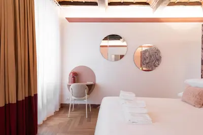 a bedroom with a bed and a mirror and a chair at My Trevi Suite & Apartment in Rome