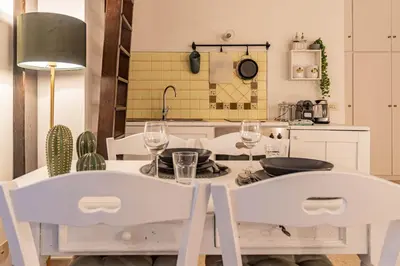 a kitchen with a table with two white chairs at Porta Pia - cozy flat in Rome