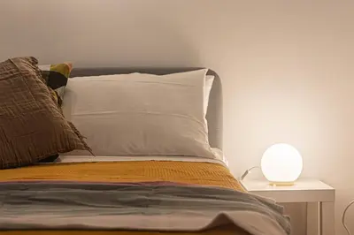 a bed with two pillows and a lamp on a table at Porta Pia - cozy flat in Rome