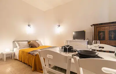 a room with a bed and a table and chairs at Porta Pia - cozy flat in Rome