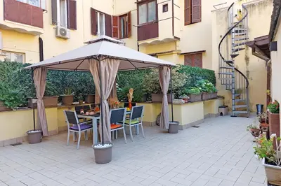 a patio with an umbrella and a table and chairs at dolce casa colosseo 1 - 2 in Rome
