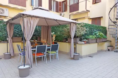 a table and chairs under an umbrella on a patio at dolce casa colosseo 1 - 2 in Rome