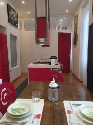 a kitchen with a wooden table and a kitchen with red cabinets at Irori Boutique House in Rome