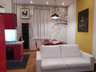 a living room with a white couch and a kitchen at Irori Boutique House in Rome