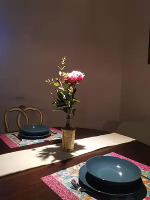a table with two plates and a vase with a flower at 