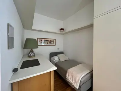 a small bedroom with a bed and a desk at Suite Vaticana 9 in Rome