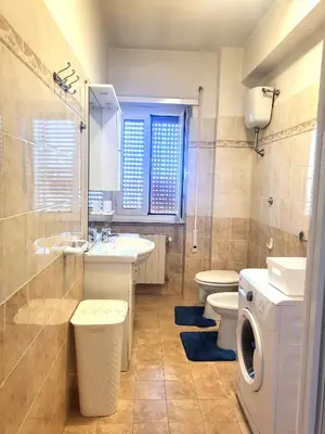 a bathroom with two sinks and a toilet and a window at Holiday Roma prenestina in Rome