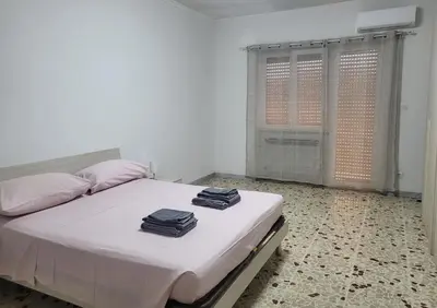a white bed with two pillows and towels on it at Holiday Roma prenestina in Rome