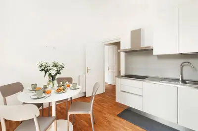 a white kitchen with a table and chairs at Rome Nice Stays in Rome