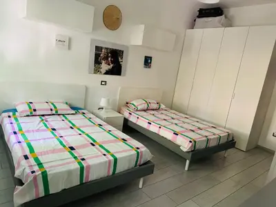 a bedroom with two beds and a clock on the wall at camera con bagno privato in Rome