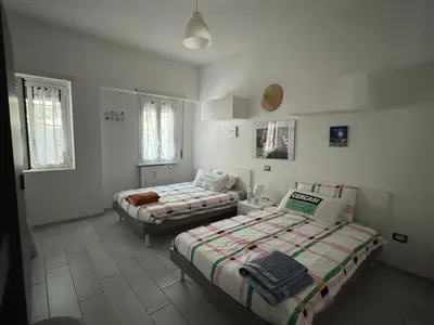 two beds in a room with white walls and windows at camera con bagno privato in Rome