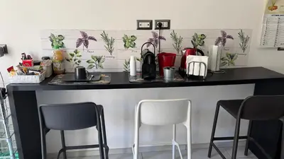 a kitchen counter with two chairs and a counter top at camera con bagno privato in Rome