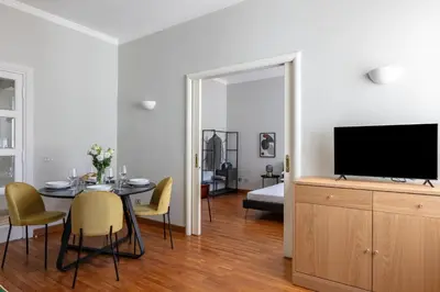 a living room with a dining table and a television at Casa Fontanella by Hili in Rome