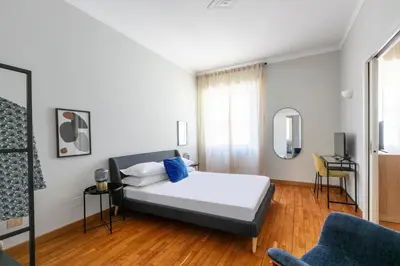 a bedroom with a bed and a blue chair at Casa Fontanella by Hili in Rome