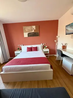 a room with a bed and a desk and a tv on the wall at Near Vatican, Irnerio 47 Guest House in Rome