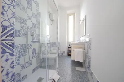 a bathroom with blue and white tiles on the walls at YCH-Vintage flat near San Giovanni in Rome