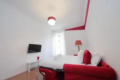 a bedroom with a bed and a red couch at YCH-Vintage flat near San Giovanni in Rome