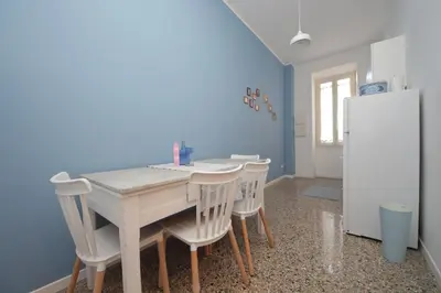 a kitchen with a table and chairs and a refrigerator at YCH-Vintage flat near San Giovanni in Rome