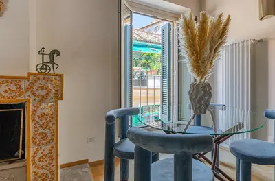a dining room with a glass table and chairs and a fireplace at Domus Beato Angelico in Rome