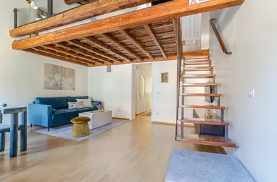 a living room with a blue couch and a spiral staircase at Domus Beato Angelico in Rome
