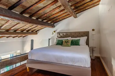a bedroom with a white bed with wooden ceilings at Domus Beato Angelico in Rome
