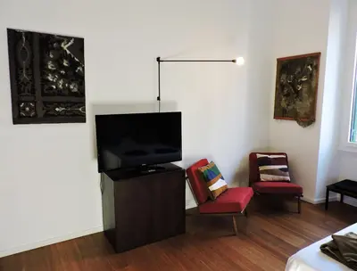 a living room with a flat screen tv and two chairs at Art Lab Residence in Rome